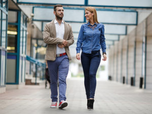 Young happy business couple communicating while taking a walk together.