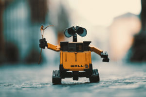 kleiner Roboter (Wall-E) fährt auf der Straße und schaut in die Kamera
