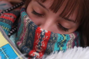 schlafende Person mit Schal vor dem Mund