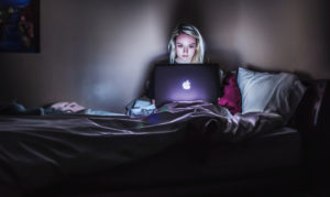 Person im Bett im Dunkeln am Laptop